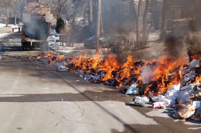 garbage truck dumps load on fire