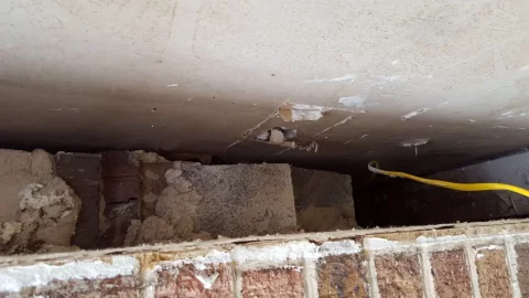 [Hearth.com] Wall pass through, a brick wall with drywall behind it.