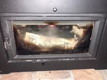 [Hearth.com] Log rolled and is touching the glass