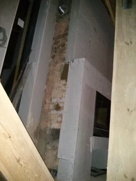 [Hearth.com] Exposed rockwool insulation around flue in decompression enclosure